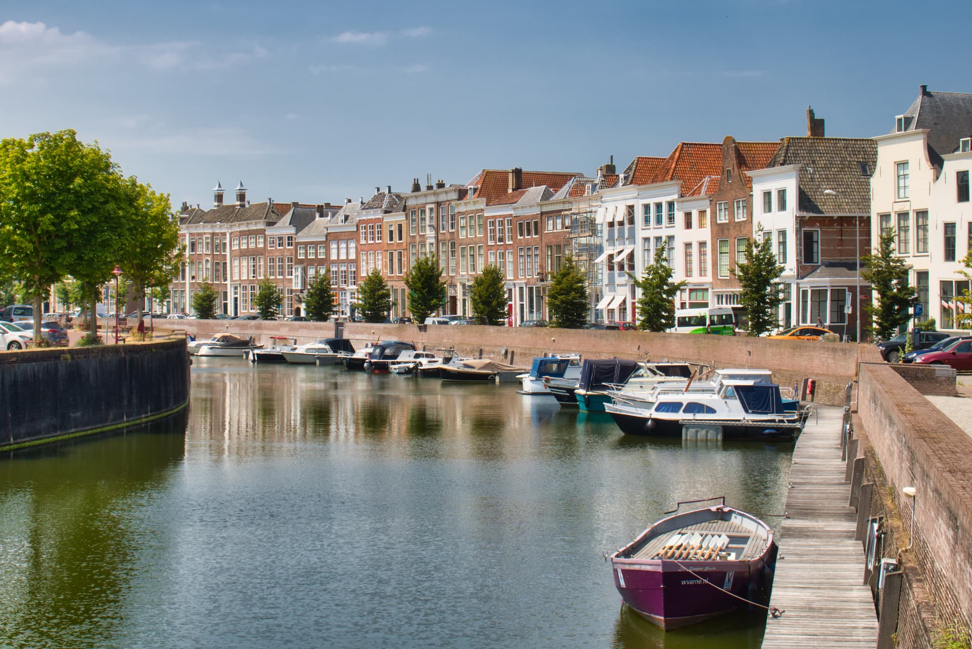 Boats moored on canal next to historic brick row houses in Middelburg.