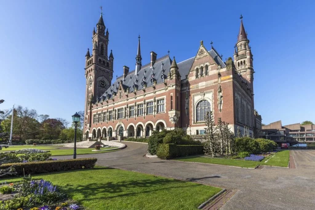 Peace Palace in The Hague with manicured lawns and bright blue sky