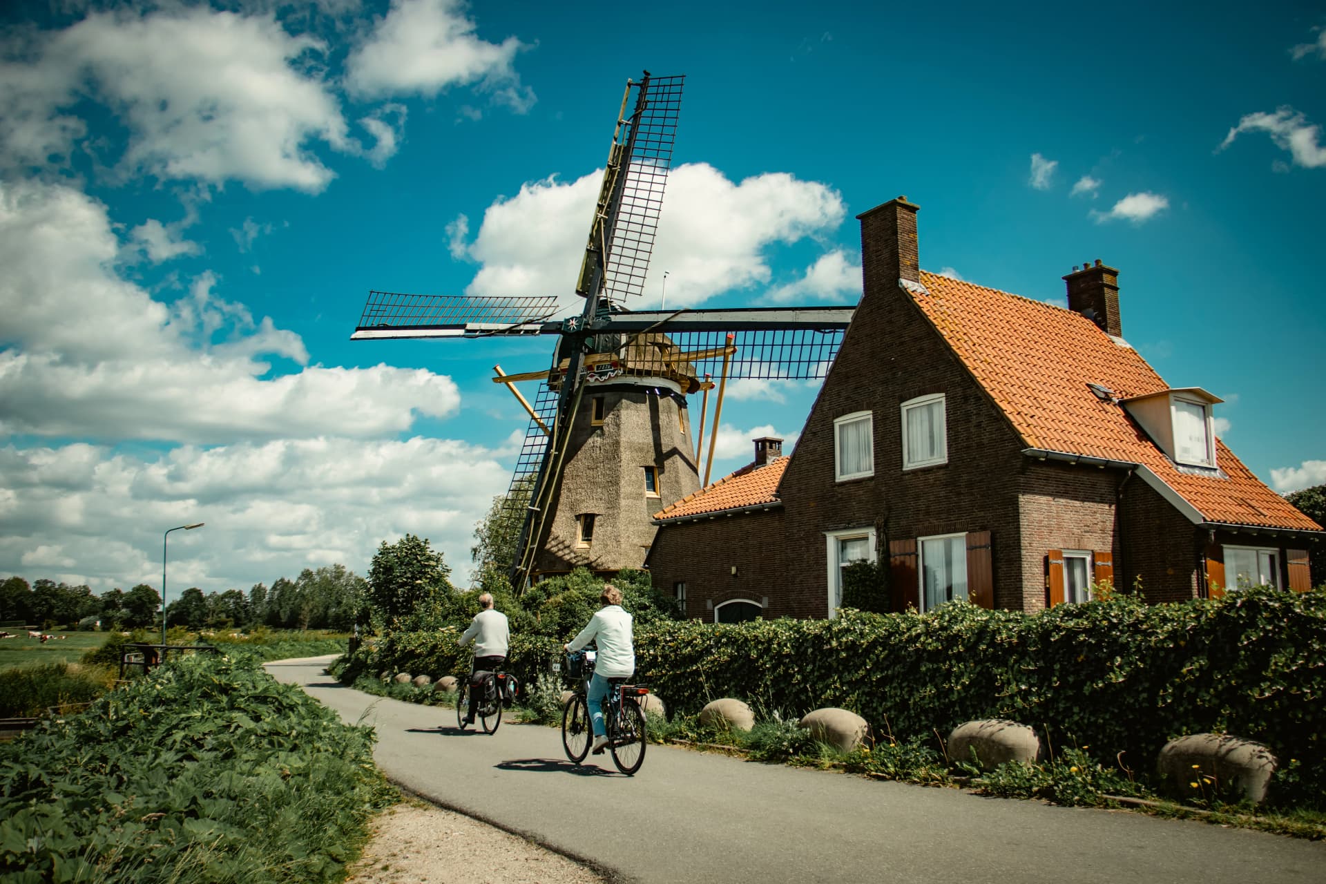 couple cycling by the windmill, Nigtevecht, Village in the Netherlands