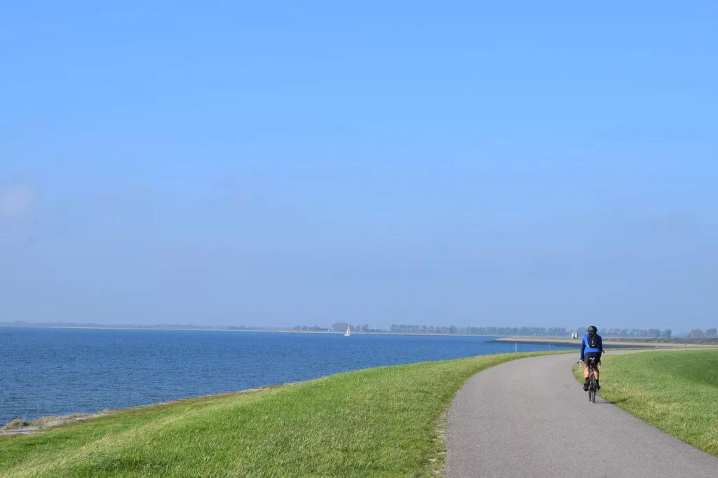 Typical dutch image of people cycling on the dike