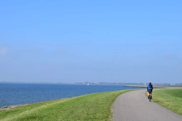 Typisk hollandsk billede af folk, der cykler på diget